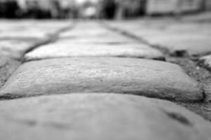 Stones of a paved road, road close view abstract black and white background photo