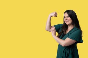 alegre joven mujer con largo pelo sonriente en un vibrante amarillo estudio foto