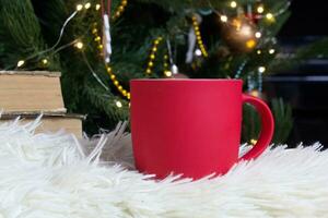 blanco rojo jarra con Navidad árbol en fondo, estera té o café taza con Navidad y nuevo año decoración,horizontal burlarse de arriba con cerámico jarra para caliente bebidas, vacio regalo impresión modelo foto