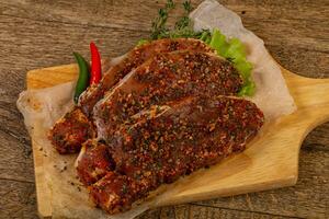 Raw marinated pork steak photo