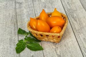 montón de tomate amarillo en el cuenco de madera foto