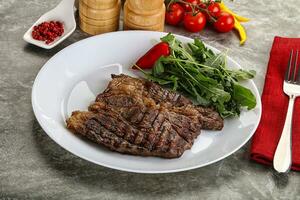 Grilled chuck roll steak with arugula photo