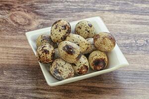 Raw quail eggs heap in the bowl photo