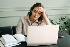 Work-Induced Weariness. Young Woman Suffers from Overwork and Stress. Modern-Day Struggles. Woman Overwhelmed by Overwork and Stress. Young Woman Sleeps at Laptop, Overworked and Stressed photo