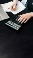 Diligent Businesswoman in Finance. Analyzing Budget, Calculating Finance Report with Calculator, Close-Up of Document. Calculating Finance Report. Woman Working in Finance and Budget photo
