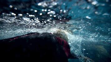 Underwater view of professional swimmer training in swimming pool, 4k 120 fps super slow motion raw video. Triathlete swim in black wetsuit video
