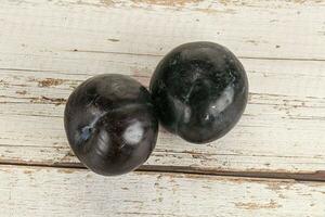 Two ripe sweet black plums photo