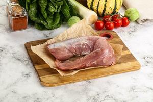 Uncooked raw pork tenderloin with spices photo