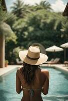 Back view of young woman in hat standing in swimming pool at resort. AI Generative photo