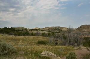 Amazing Geological Landscape of Field with the Badlands in the Distance photo