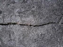 Grungy wall of gray concrete texture with cracked surface from sand and cement materials. photo