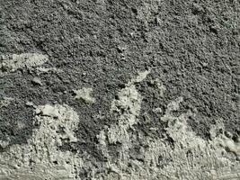 Grungy wall of gray concrete texture with cracked surface from sand and cement materials. photo