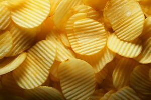 Closeup top view of crispy potato chips creating a textured background AI Generated photo