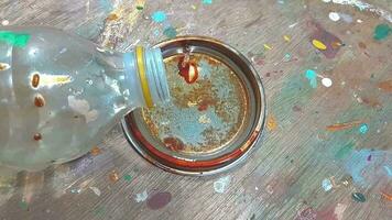 pouring paint thinner in container at workshop video