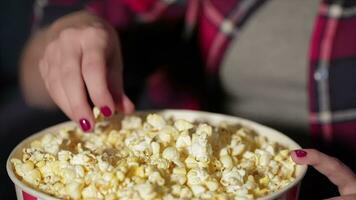 Close up bucket of popcorn and a hand of the girl video