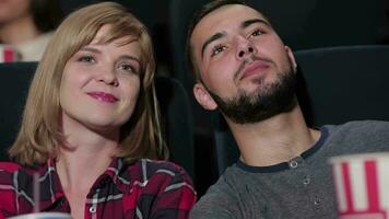 Young couple sitting in multiplex movie theater video