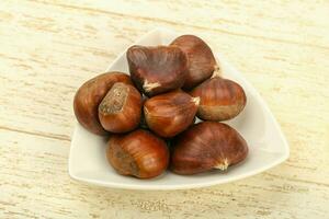 Chestnut over wooden background photo