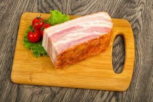 Raw bacon over wooden background photo