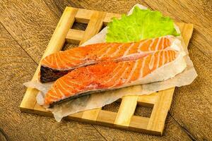 Raw salmon over wooden background photo