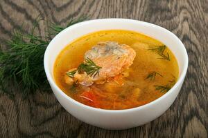 Salmon soup over wooden background photo