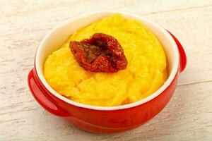 Polenta over wooden background photo