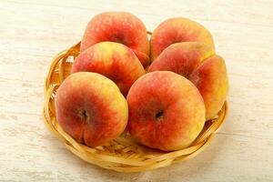 Sweet peaches over wooden background photo