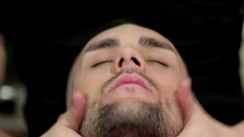 Barber doing facial massage in the men's hair salon video