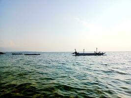 View of Benoa Bay beach in Bali with fishing boats anchored in the morning photo