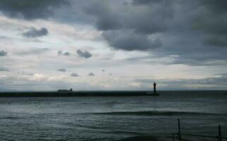 sunset on the harbor with lighthouse photo