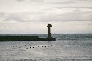 Cloudy harbor with central lighthouse photo