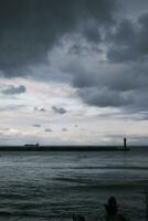 Cloudy harbor with central lighthouse photo