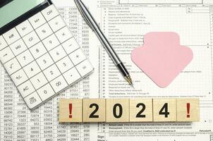 2024 words on wooden blocks with sticker, calculator and pen photo