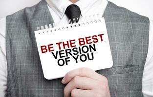 Businessman with notebook with text BE THE BEST VERSION OF YOU photo