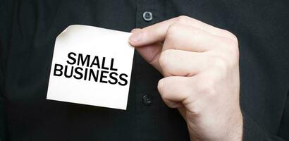 Businessman holding a card with text SMALL BUSINESS, business concept photo
