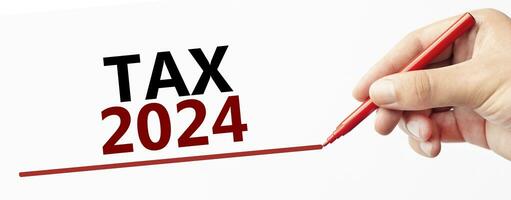 tax 2024 on white background with pen and hand photo