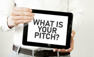 Text WHAT IS YOUR PITCH on tablet display in businessman hands on the white background. Business concept photo