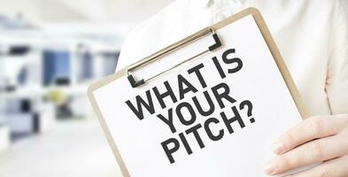 Text WHAT IS YOUR PITCH on white paper plate in businessman hands in office. Business concept photo