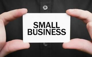 Businessman holding a card with text SMALL BUSINESS , business concept photo