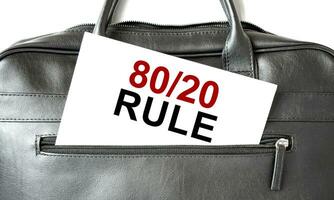 Text 80 and 20 rule writing on white paper sheet in the black business bag. Business concept photo