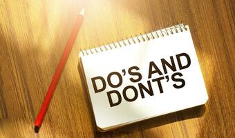 DO's and DONT's on notebook with red pencil on wooden background photo