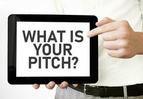 Text WHAT IS YOUR PITCH on tablet display in businessman hands on the white background. Business concept photo