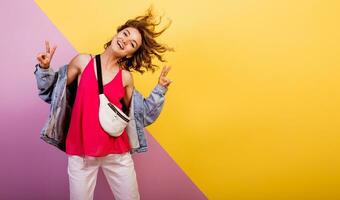 gracioso mujer con corto ondulado pelos bailando y teniendo divertido en multicolor antecedentes. Copiar espacio para texto. foto