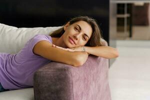 Brunette pretty woman in cozy home wear enjoying lazy weekends in her own house. Stylish modern interior. photo