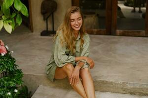 Beautiful blond woman in stylish  tropical villa. Wearing summer linen costume. photo