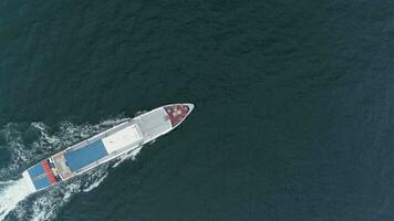 Small white cruise ship is sailing in sea. Drone is hovering. Aerial view video