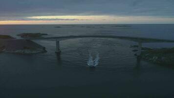 atlantisch Ozean Straße im Norwegen beim Sommer- Sonnenuntergang. Schiff ist Vorbeigehen unter storseisundet Brücke. Antenne Sicht. Drohne ist umkreisen um video