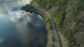 Flying Over Road with Car and Kroderen Lake Shore in Norway. Aerial Shot. Green Mountain with Trees. Drone is Flying Forward, Camera is Tilting Up video