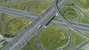 complex weg knooppunt en auto's verkeer Bij zonnig zomer dag. dar is in een baan om de aarde in de omgeving van. antenne tijd vervallen in beweging. hyperlapse video