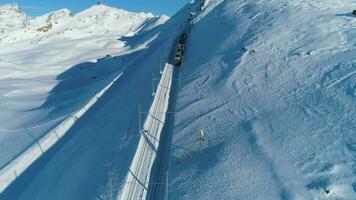 gornergrat berg en tand spoorweg trein in zonnig winter dag. antenne visie. Zwitsers Alpen, Zwitserland. dar vliegt naar voren, camera kantelt omhoog. onthullen schot video