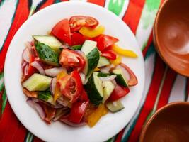 Tomato, cucumber, sweet pepper and onion salad, seasoned with oil. Asian style photo